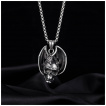 Pendentif homme dragon posé sur un crane humain en acier