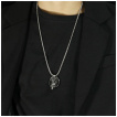 Pendentif homme dragon posé sur un crane humain en acier